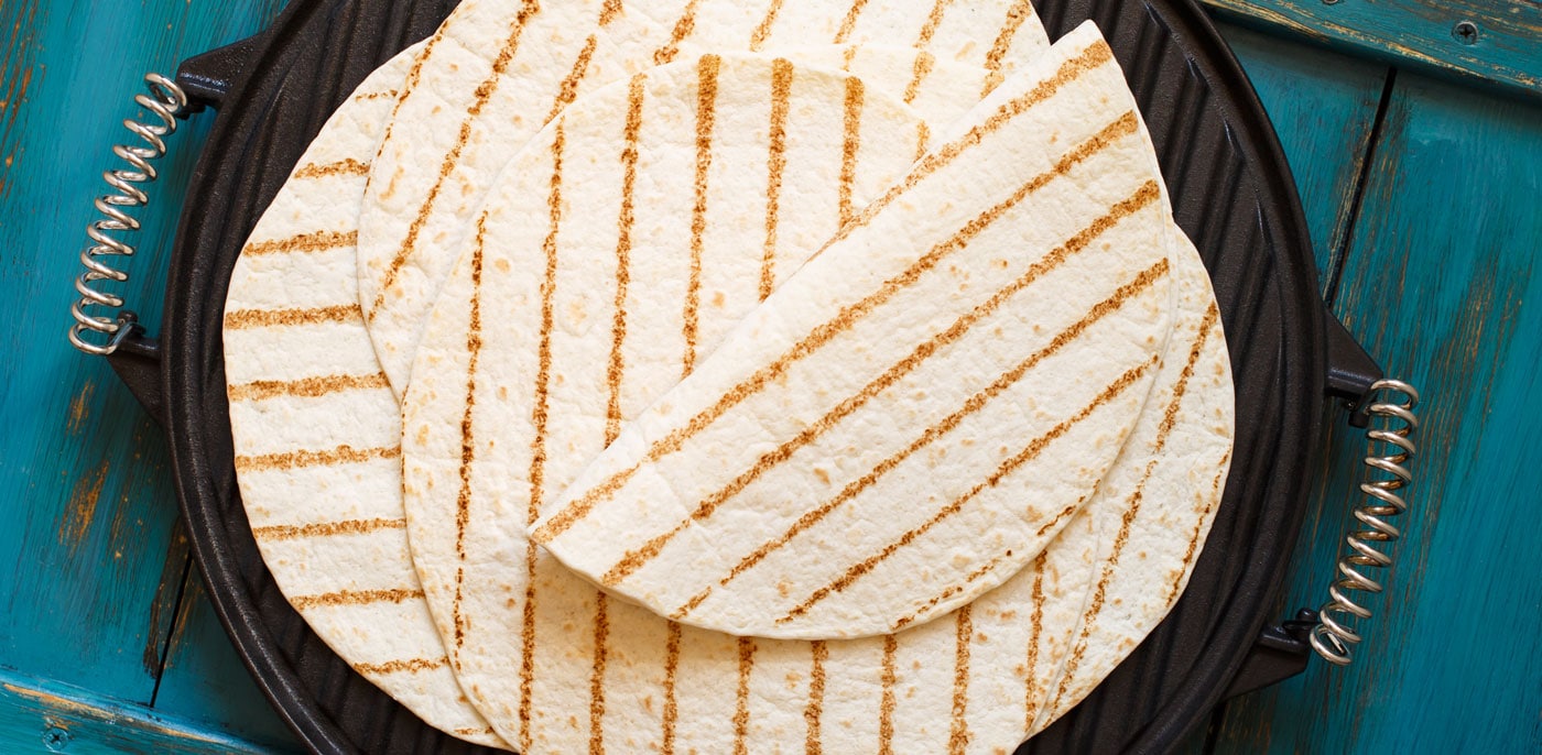 Soft tortillas with grill marks on a cast iron skillet