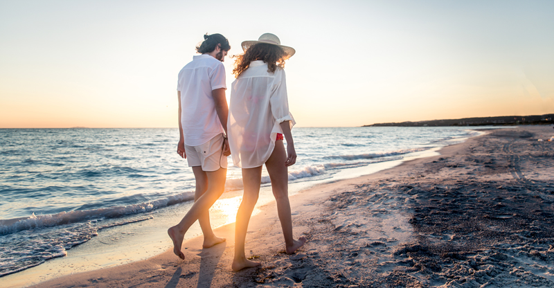 End of summer Couple enjoying a romantic stroll on the beach